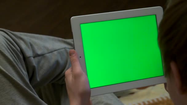 Zadní pohled rozmazané člověka drží tablet s prázdná obrazovka upravitelná zelené. Muž hospodářství tablet s zelenou obrazovkou - zadní pohled — Stock video
