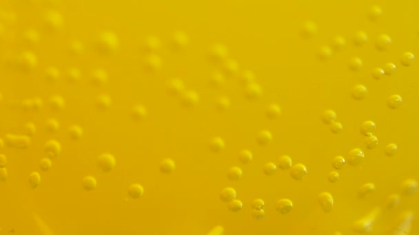 Orange soda with bubbles background. Fresh orange fruit in a glass of soda water. Orange summer drink with bubbles. Bubbles floating in the liquid orange drink. — Stock Video