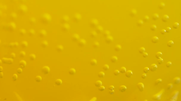 Orange soda with bubbles background. Fresh orange fruit in a glass of soda water. Orange summer drink with bubbles. Bubbles floating in the liquid orange drink. — Stock Video