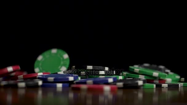 Падіння покерних фішок ізольовано на чорному тлі. Падіння покерних фішок ізольовано на чорному тлі. Барвисті покерні фішки падають за столом на чорному тлі. Відтворення фішок, що летять на чорному — стокове відео