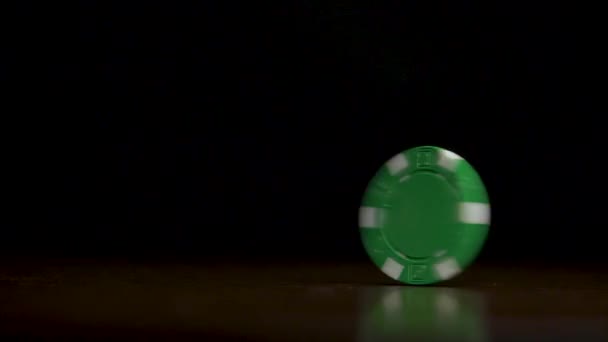 Poker chip spinning on a wooden table with black background — Stock Video