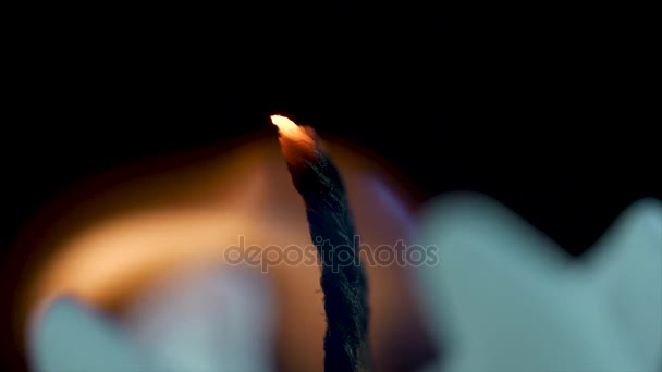 Feche de uma chama de vela em um fundo preto. Vela branca com fundo escuro. Queimando velas em um fundo escuro com luz quente — Vídeo de Stock