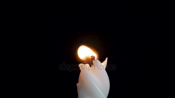 黑色背景白色长蜡烛。单蜡烛火焰灯。长的火焰, 旧的蜡烛。白色的蜡烛, 黑色的背景。深色背景上的白色光泽圆柱灯 — 图库视频影像