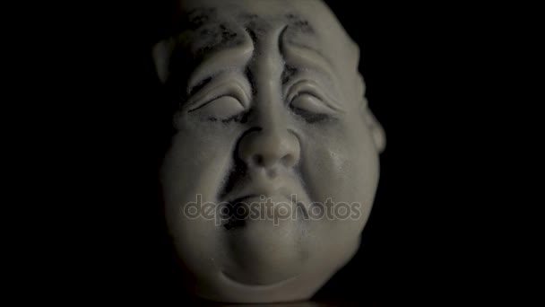 Czarno-białe figurka dramatyczne twarzy z bliska. Biały statuetki smutną twarz. Zbliżenie, statuetki, figurka głowy młodego mężczyzny smutna na czarnego tła. Smutną twarz — Wideo stockowe
