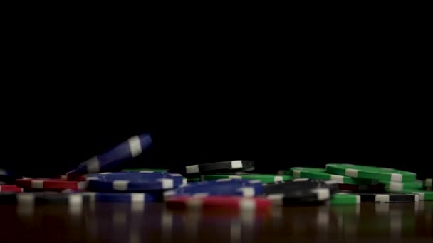 Dalende pokerfiches geïsoleerd op zwarte achtergrond. Kleurrijke pokerfiches vallen aan de tafel op zwarte achtergrond. Chips vliegen op de zwarte achtergrond spelen — Stockvideo