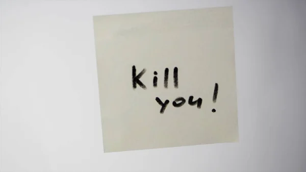 Inscription KILL YOU on a piece of paper on the glass, the concept of aggression. Inscription on the sticker — Stock Photo, Image
