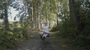 Ormanda salıncak güzel kız. Genç kadın ormanda bir salıncak sürmek