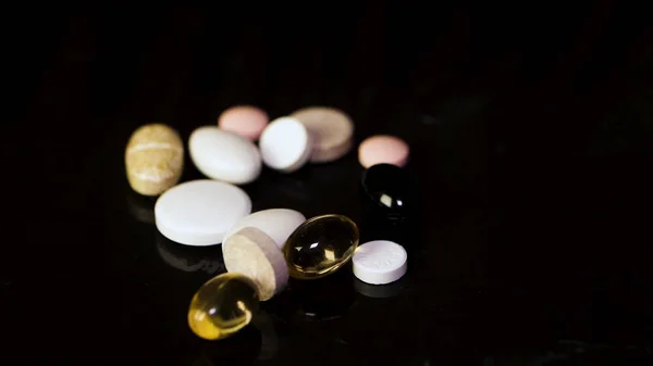 Pharmacy background on a dark table. Levitation pills. Tablets on a dark background which falling down. Pills. Medicine and healthy. Close up of capsules. Pills falling on black background — Stock Photo, Image