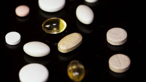 Pharmacy background on a dark table. Levitation pills. Tablets on a dark background which falling down. Pills. Medicine and healthy. Close up of capsules. Pills falling on black background — Stock Photo, Image