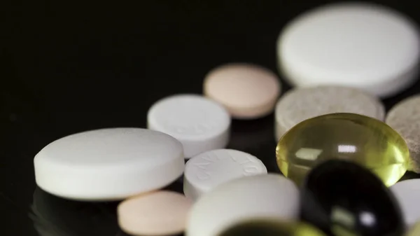 Pharmacy background on a dark table. Levitation pills. Tablets on a dark background which falling down. Pills. Medicine and healthy. Close up of capsules. Pills falling on black background — Stock Photo, Image