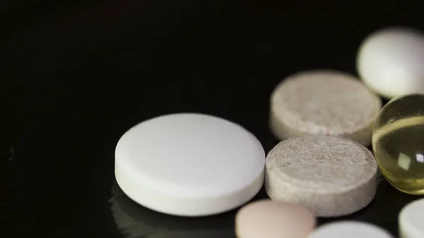 Pharmacy background on a dark table. Levitation pills. Tablets on a dark background which falling down. Pills. Medicine and healthy. Close up of capsules. Pills falling on black background — Stock Photo, Image