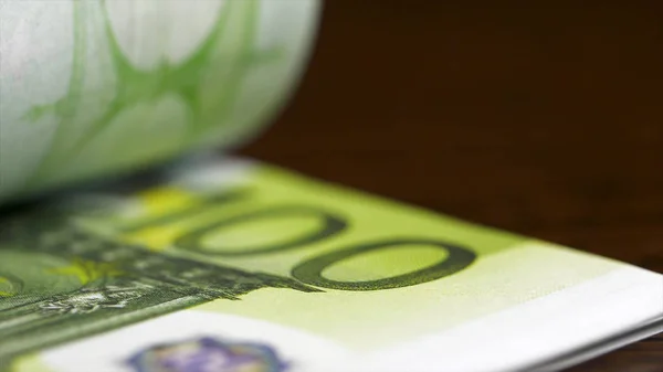 计算100欧元钞票特写。欧元钞票的计数接近黑色背景。欧元钞票落在木桌上。货币概念 — 图库照片