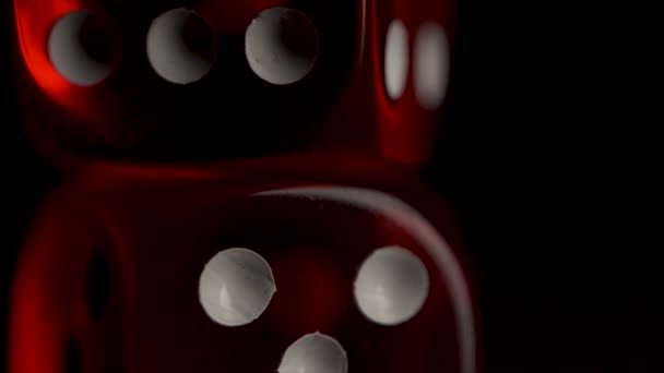 Two red casino dices on the black background. Shot glasses with dice and ribbon. risk concept - playing dice at black wooden background. Playing a game with dice. Red casino dice rolls. — Stock Video