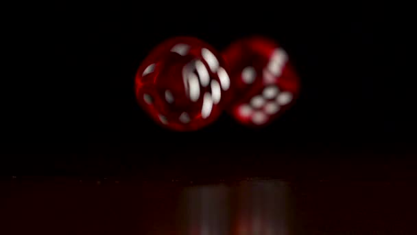 Rode dobbelstenen vallen op zwarte achtergrond. Casino concept. Twee rode dobbelstenen spelen op houten tafel met donkere achtergrond — Stockvideo