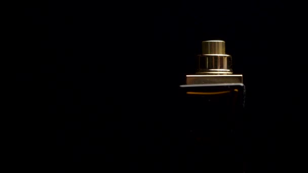 Close up of a spray bottle drops on black background. Male perfume bottle on a dark background. close up of a spray bottle drops on black background — Stock Video