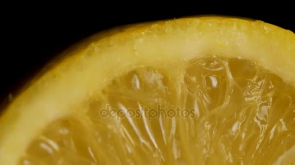 Limão seccional sobre fundo preto. Meio limão sobre um fundo preto. fatia de limão em preto isolado — Vídeo de Stock