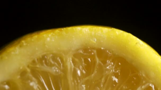 Citron sectional på svart bakgrund. Halv citron på en svart bakgrund. skiva på svart isolerade — Stockvideo