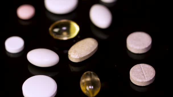 Φαρμακείο φόντο σε έναν μαύρο πίνακα. Δισκία σε μαύρο φόντο. Χάπια. Ιατρική και υγιεινή. Κοντινό πλάνο, κάψουλες. Διαφορετικού είδους φάρμακα. Διάφορα χάπια — Αρχείο Βίντεο
