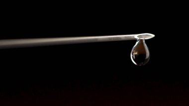 Şırınga iğne ilaç sıvı ilaç damla siyah bir arka plan ile kapatın. Damla şırınga close-up. NIB tarih seçici odak