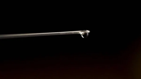 Close-up da agulha da seringa com gota isolada sobre fundo preto. gota de água da agulha da seringa. Fecha. Close-up de seringa médica com medicamento — Fotografia de Stock