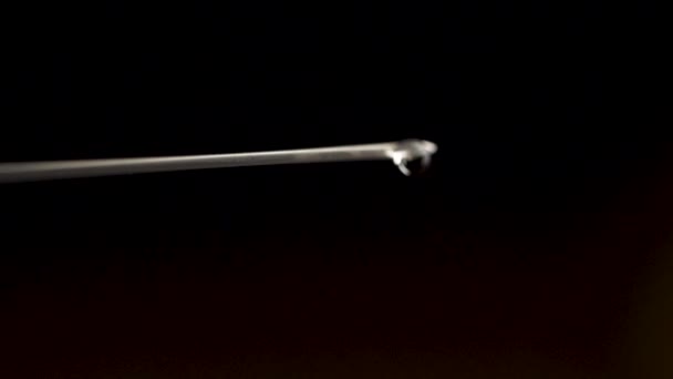 Close-up of syringe needle with drop isolated on black background. Water drop from syringe needle. Close up. Close-up of medical syringe with drug — Stock Video