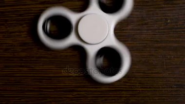 En iyi görüntü beyaz spinner siyah ve ahşap zemin üzerinde. Siyah topluca spinner oyuncak. Serin yeni iplik oyuncak yetişkin gençler için. Tepki geliştirmek için popüler spinners ile oynamak eğlenceli yapan.
