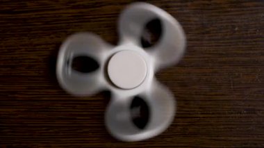 En iyi görüntü beyaz spinner siyah ve ahşap zemin üzerinde. Siyah topluca spinner oyuncak. Serin yeni iplik oyuncak yetişkin gençler için. Tepki geliştirmek için popüler spinners ile oynamak eğlenceli yapan.