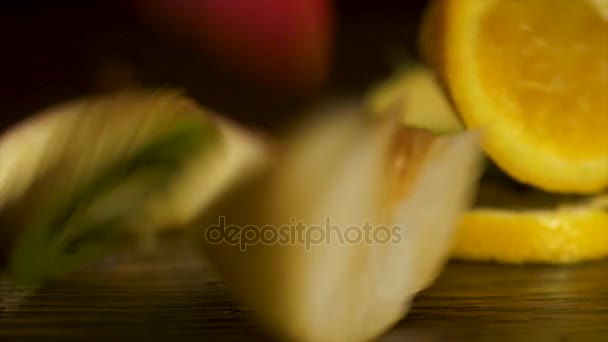 Rich harvest of various fruits and vegetables: decorative pumpkins, squash, apples, pears, pomegranates and grapes fall on the dark wooden background. Fresh, delicious sliced fruits fall on the table