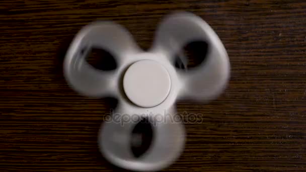 Biały top wiew pokrętła na tle czarnego i drewniane. Fidget czarny spinner zabawka. Fajne nowe zabawki spinning dla młodych osób dorosłych. Zagraj z popularnych błystki do poprawy reakcji zabawy, Robienie sztuczek. — Wideo stockowe