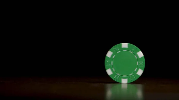 Обертання покерних фішок на столі ізольовано на чорному тлі. Покерні чіпси обгортаються. Чіп покер, що крутиться на столі ізольовано на темному фоні — стокове фото