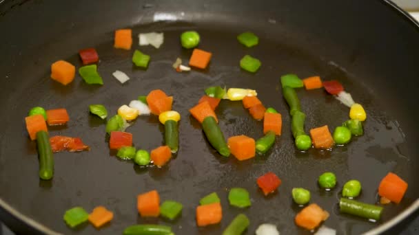 在盘子里切碎的蔬菜是在食物中收集的。在锅里炒蔬菜。蔬菜在半空中飞行, 从煎锅中被翻转过来。素食吃准备蔬菜膳食 — 图库视频影像