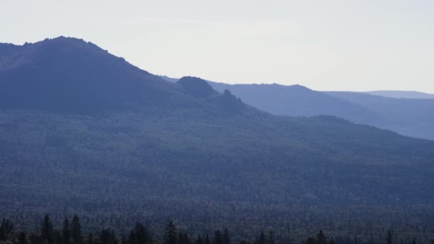 Φθινοπωρινό τοπίο βουνού με πολύχρωμα δάση. Μπλε του ουρανού. Μπλε βουνού με το γαλάζιο του ουρανού και το σύννεφο — Αρχείο Βίντεο