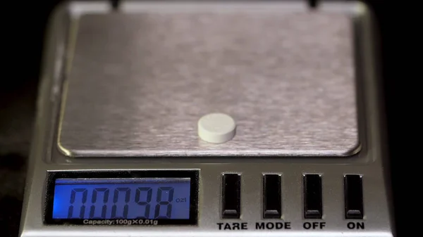Diet pills on a scale. Weight loss medicine spilled. Tablet on the scales for accurate weight measurement to avoid overdose — Stock Photo, Image