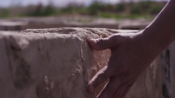 手のタッチ、石の壁。手マンに触れる石の壁。ネイティブの土地の場所、憧れの男祖国のコンセプト — ストック動画