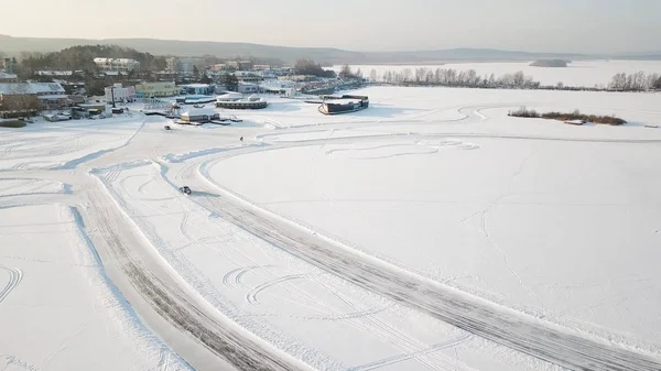 Jedno auto, jízdy po zimním lese na venkovské silnici. Pohled shora z DRONY. Letecký pohled na sněhu v zimě, auto kolem krytý silniční. Pohled shora z auto na zasněžené vozovce — Stock fotografie
