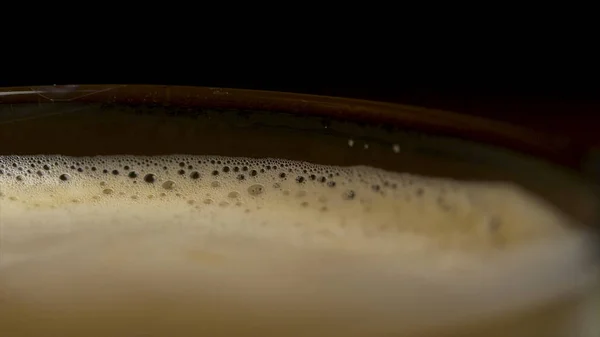 Close-up of coffee foam isolated over a black background, viewed from top. Black espresso coffee with heady froth in a glass mug or cup. close-up shot of barista coffee cup — Stock Photo, Image