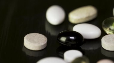 Siyah arka plan üzerine çeşitli renkli hapları. Siyah arka plan üzerine birkaç ilaç yığını. Renkli hapları koyu arka plan üzerinde. Siyah Cam zemin üzerine beyaz hap. Sağlık Eczanesi