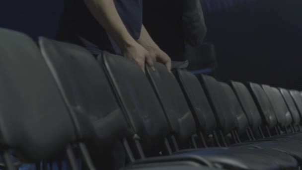 Stühle in Theatern oder Kinos. Mann richtet Stühle im Theater auf und bereitet sich auf die Präsentation vor — Stockvideo