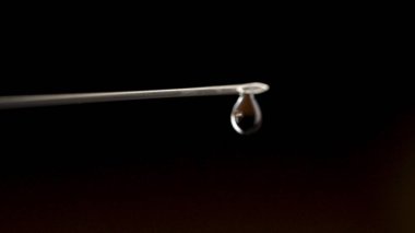 Şırınga iğnesi Close-Up izole üzerinde siyah arka plan damla. Su damla şırınga iğne. Yakın çekim. Tıbbi şırınga uyuşturucu ile yakın çekim