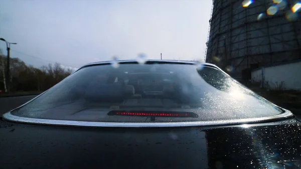 Vettura vista dal lunotto posteriore. Un filmato. Guida di un'auto durante il giorno, macchina fotografica truccata sul retro o sul bagagliaio di un'auto nera tedesca . — Foto Stock