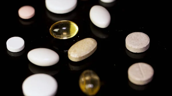 Various colorful pills on black background. Pile of several medicines on black background. Colorful pills over dark background. white pills on black glass background. medical pharmacy — Stock Photo, Image