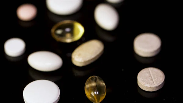 Various colorful pills on black background. Pile of several medicines on black background. Colorful pills over dark background. white pills on black glass background. medical pharmacy — Stock Photo, Image