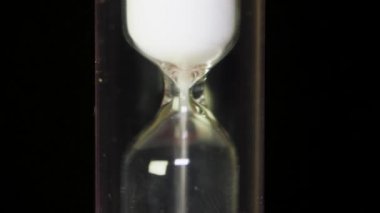 Zaman geçer - blackbackground üzerinde beyaz kum ile cam kum saati. Klasik tarzı Vintage eski kum saati kum saati saat. Makro
