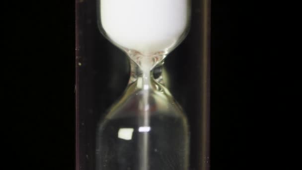 Time Passes - Reloj de arena de vidrio con arena blanca sobre fondo negro. Reloj de arena de reloj clásico estilo vintage viejo reloj de arena. Macro — Vídeos de Stock