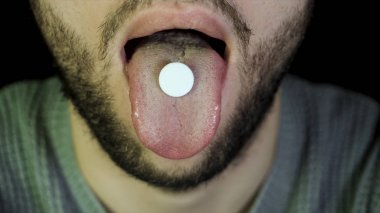 Sakallı adam bir hapı yutar. Adam gösteren tablet dil üzerinde kapatın ve bu, kavramını tıp ve sağlık yutar