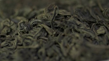Kuru çay, kurutulmuş yaprakları. Arka plan siyah çay yaprakları. kuru yaprak yeşil çay beyaz bir arka plan üzerinde. Kuru çay kazık, yakın çekim