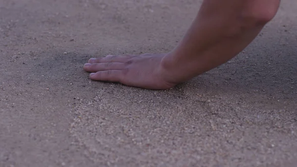 El primer plano de la mano de los hombres tocando la arena en la orilla del mar - concepto de lugar nativo. hombre sostiene su mano sobre la arena en la playa - concepto de vacaciones y turismo. Arena en la mano en la arena verde — Foto de Stock