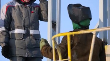 Dikiz site oluşturma ayakta iki inşaatçılar. İki işçi inşaat alanında konuş. Site oluşturma ayakta iki inşaatçılar portresi