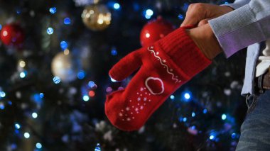 Noel arka plan, sevinç kış zamanında kavramı kırmızı yün eldiven elinde dışarı yayılır. Adamın elinde bir Noel mitten giydiğini