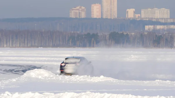 Neumáticos de invierno de un coche en una carretera nevada. Los neumáticos en la carretera están cubiertos de nieve en un día de invierno. Conduce en un camino nevado —  Fotos de Stock